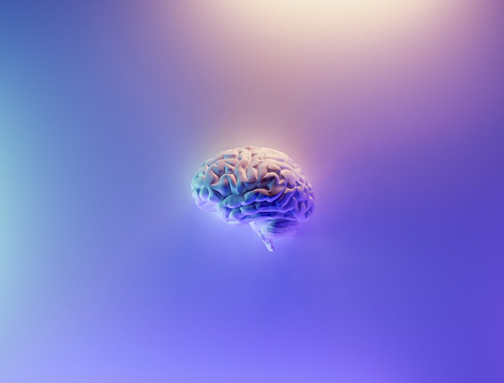 Image of a purple and blue brain floating on a purple and blue background. Image represents how highly sensitive people (HSPs) have brains that are wired differently. Free mental health support blog. Image from Caitlin Imray Therapy in Stirling blog. 